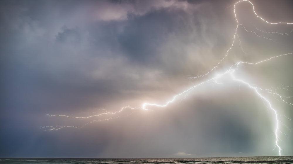 Lightning over the Gulf behind an empty lifeguard stand
