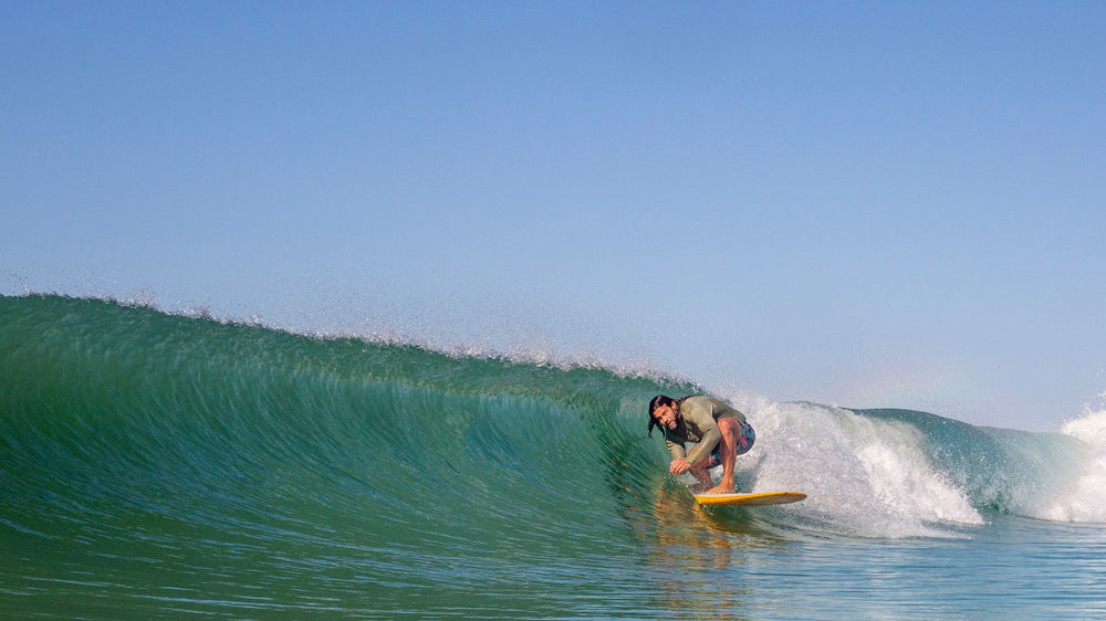 Surfer riding inside a clean green barrel