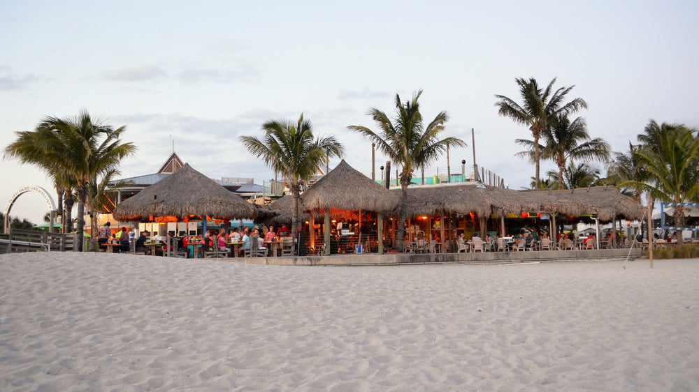 Thatched beach bar and umbrellas on the sand at Sharky's on the Pier in Venice