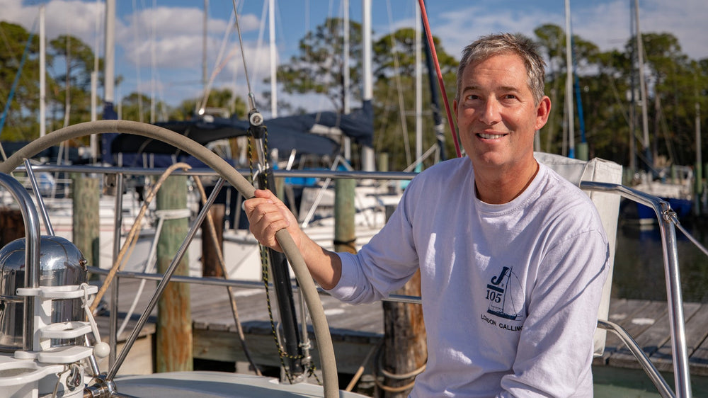 Pete Boland at the wheel of his J/105 sailboat in the marina