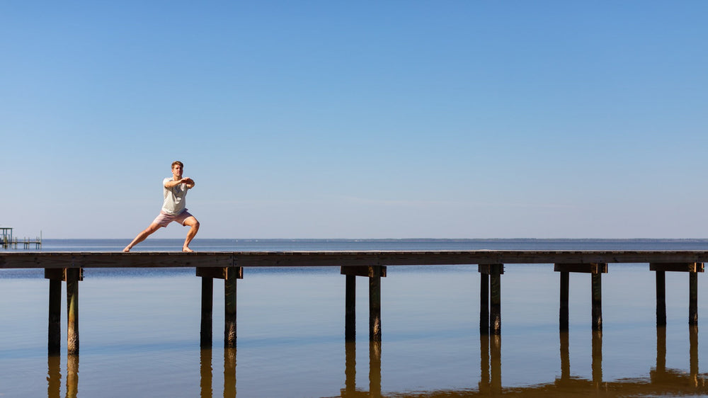 A trainer lunging at the end of a long dock over calm water