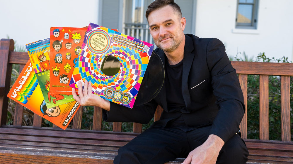 Scott Lassiter, DJ 30A, holding a fan of vinyl records on a bench