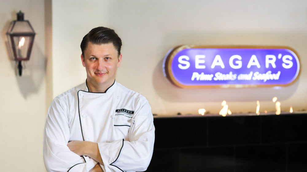 Chef Fleetwood Covington standing beneath the Seagar's Prime Steaks and Seafood sign