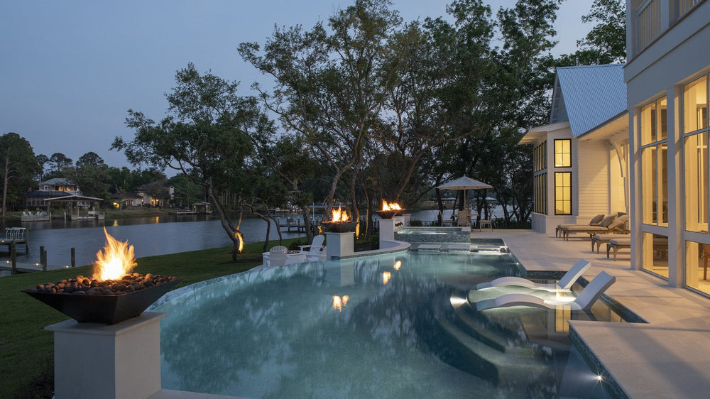 A coastal pool and fire pit at dusk