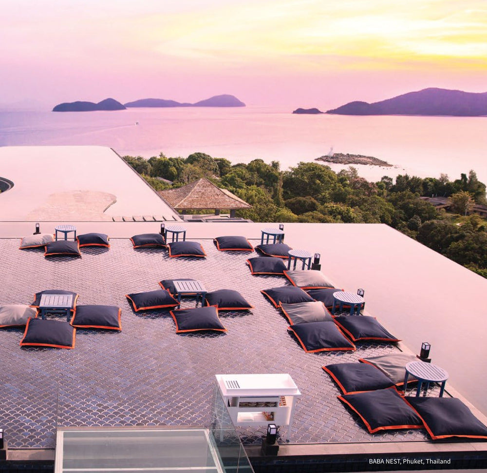 Floor cushions on the Baba Nest rooftop platform above the Andaman Sea at sunset