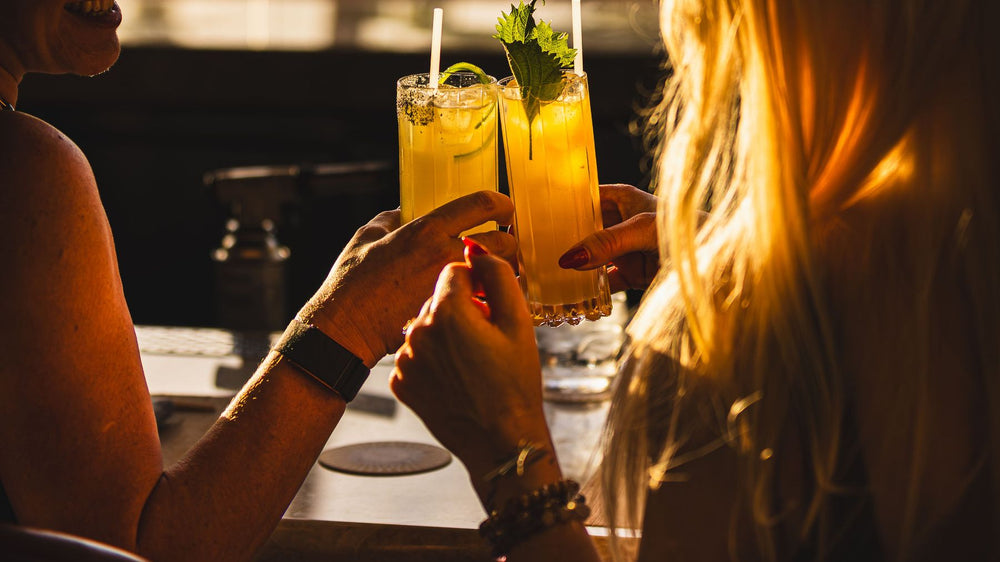 Two friends toast garden-to-glass cocktails at golden hour