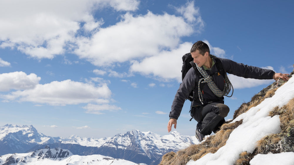 Bear Grylls climbing a snowy ridge